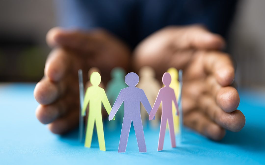 Image of a pair of hands shielding a circle of paper cut out people