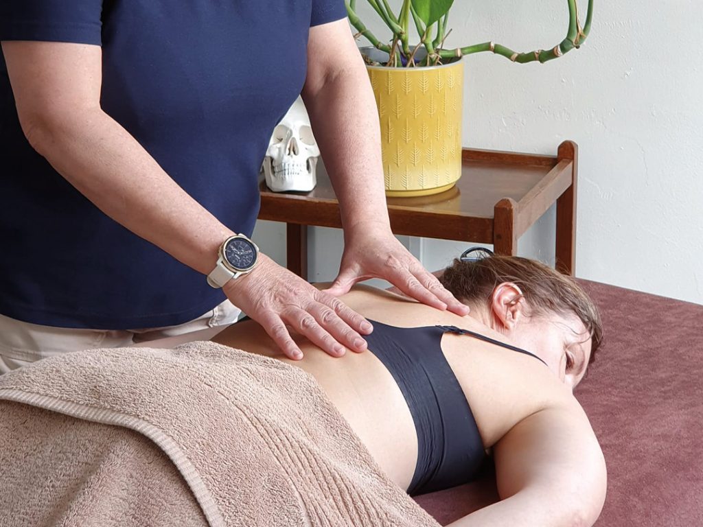 Image of Helen applying a Bowen move on a person lying on a massage table