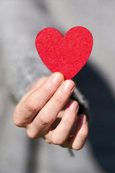 Image of a person holding a paper heart describing emotional reset